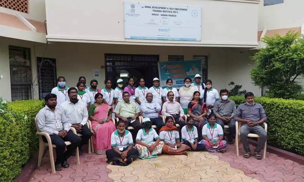 Canara Bank RM T Ramakrishna and others with the women tailoring trainees at RUDSETI in Ongole on Sunday