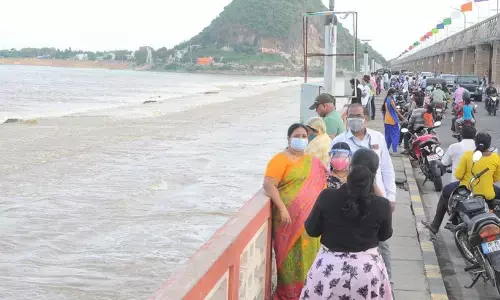 Visitors watching water discharge into sea at Prakasam barrage in Vijayawada on Sunday