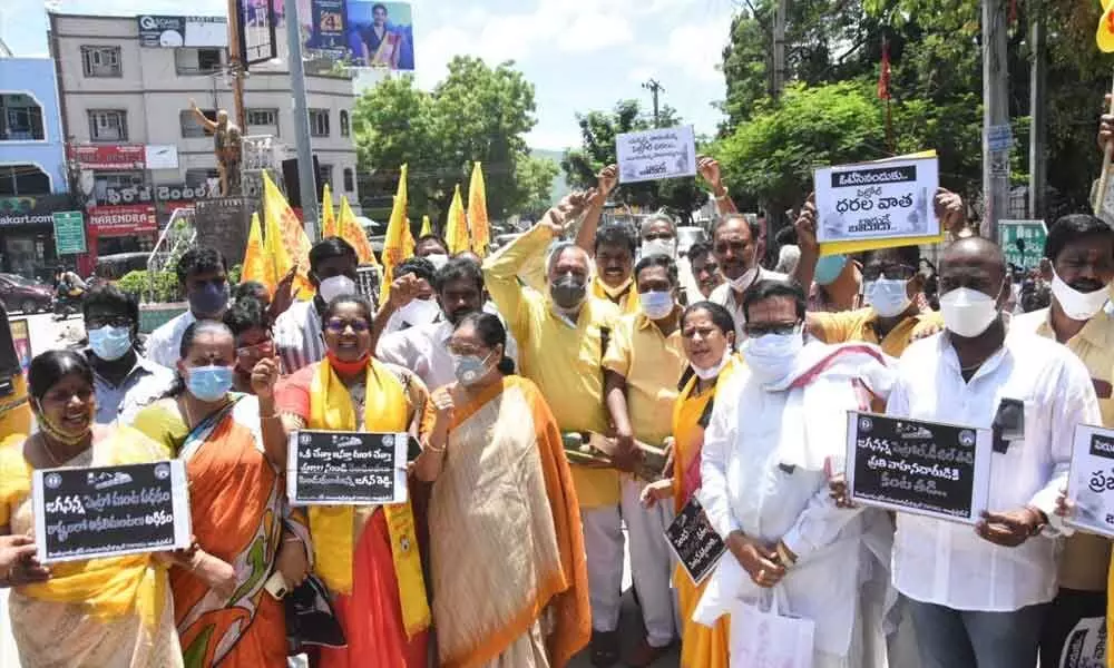 TNTUC leaders staging a protest at the municipal office junction against the hike in fuel prices in Tirupati on Monday