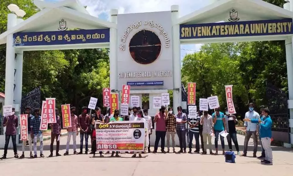 AIDSO leaders staging a dharna at SV University main entrance demanding postponement of semester examinations in Tirupati on Monday.