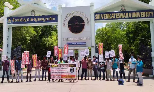 AIDSO leaders staging a dharna at SV University main entrance demanding postponement of semester examinations in Tirupati on Monday.