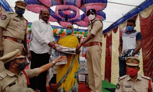 OSD N Surya Chandra Rao and others officails distributing cloths to an old woman in Ravikona on Tuesday