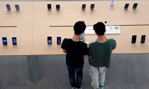 People look at smartphones in Huaweis first global flagship store in Shenzhen (Photo/Reuters)