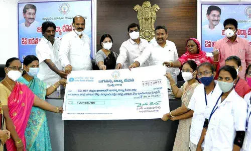 Endowments minister Velampalli Srinivas, MLAs, Krishna District Collector J Nivas and others handing over the Jagananna Vidya Deevena cheque replica to the beneficiaries in Vijayawada on Thursday