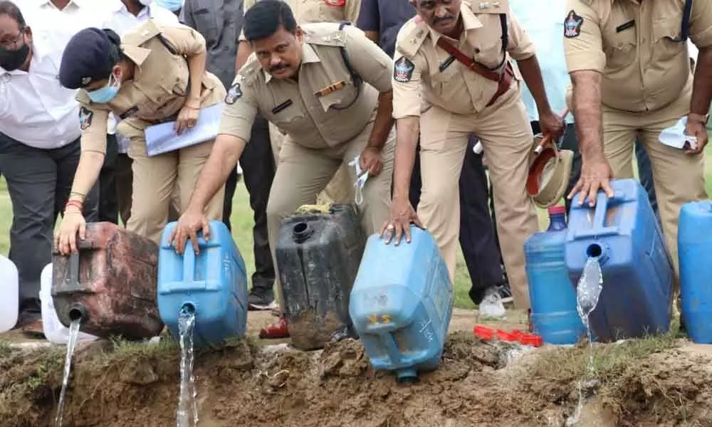 Police officials destroying jaggery wash
