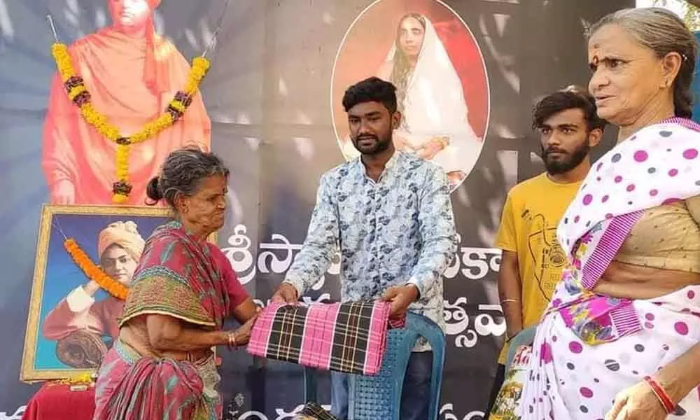 Kaki Santosh Kumar distributing clothes and dry ration to residents of a slum area in Visakhapatnam.