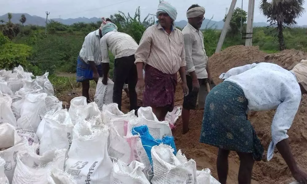 Sand bags being kept ready to check breaches near Varadhi in Vijayawada