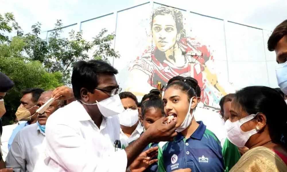 Transport Minister Puvvada Ajay Kumar offering cake to a sports girl during a programme at Sardar Patel stadium in Khammam on Monday