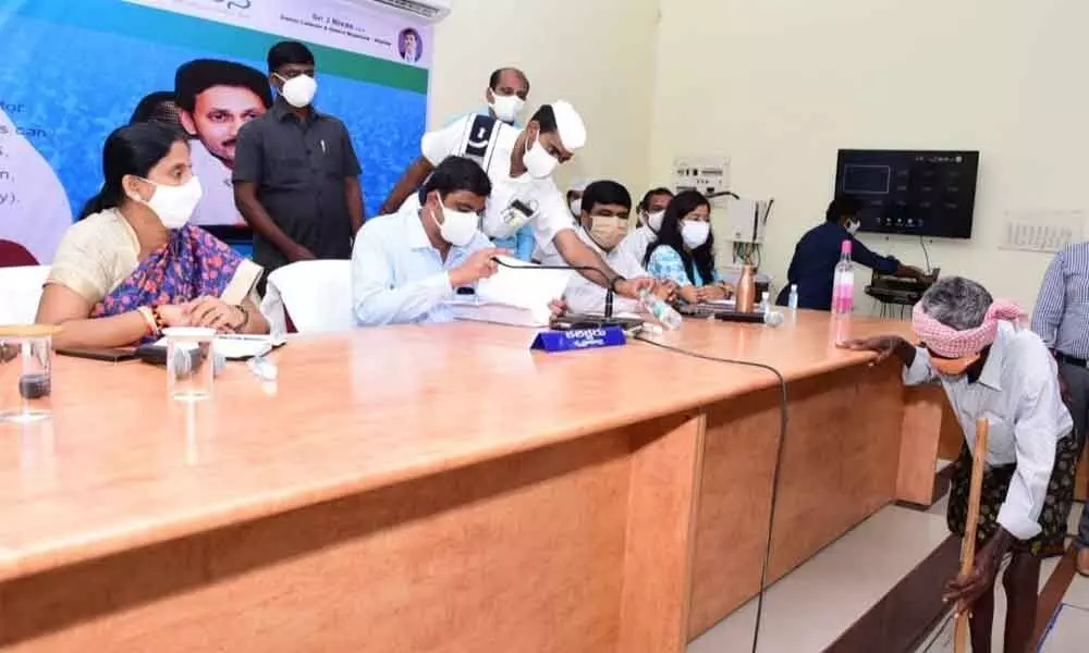 Krishna district collector J Nivas, joint collectors and other officials participate in Spandana programme at the collectorate in Machilipatnam on Monday.
