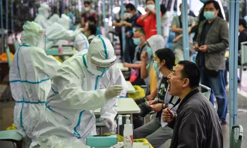 A medical worker takes a swab sample from a resident to be tested for the COVID-19 in Wuhan (File Pic Courtesy: VOA News)