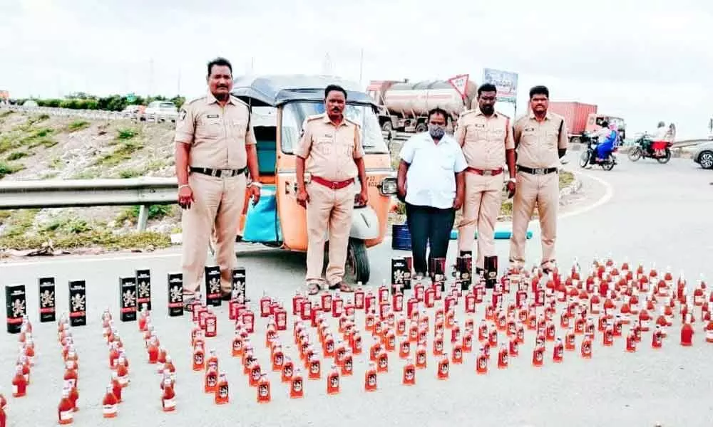 SEB Circle Inspector P Srinivasulu and his staff with seized liquor bottles at Panchalingala border check post on Thursday.