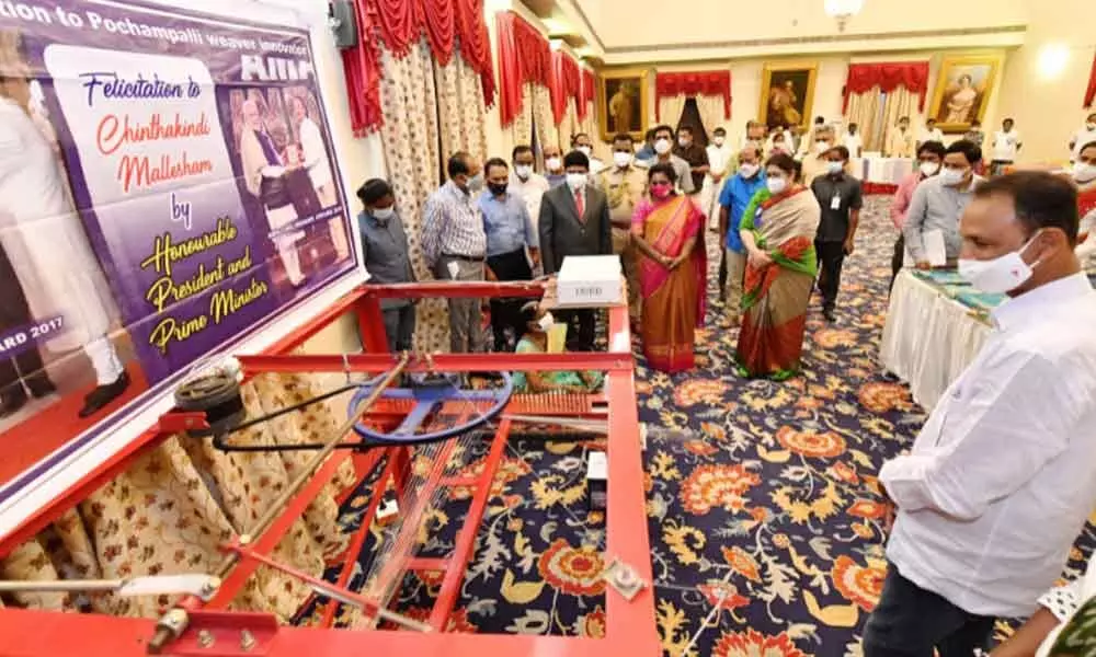 Governor Dr Tamilisai Soundararajan examining the weaving machine developed by Padma Shri awardee Chintakindi Mallesham  at Raj Bhavan on Saturday