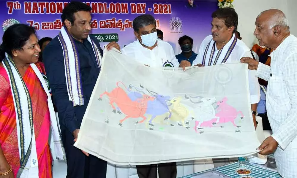 Advisor to the State govt Sajjala Ramakrishna Reddy and Minister for Textiles, Handlooms and Industries M Goutham Reddy looks at a handloom product at a programme organised on the occasion of National Handloom Day at Apco Bhavan in Vijayawada on Saturday