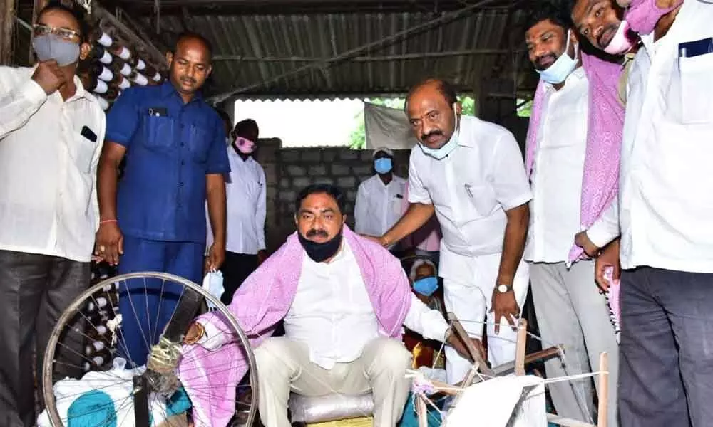 Minister for Panchayat Raj Errabelli Dayakar Rao rolling charkha (spinning wheel) at Kamalapur on the occasion of National Handlooms Day on Saturday