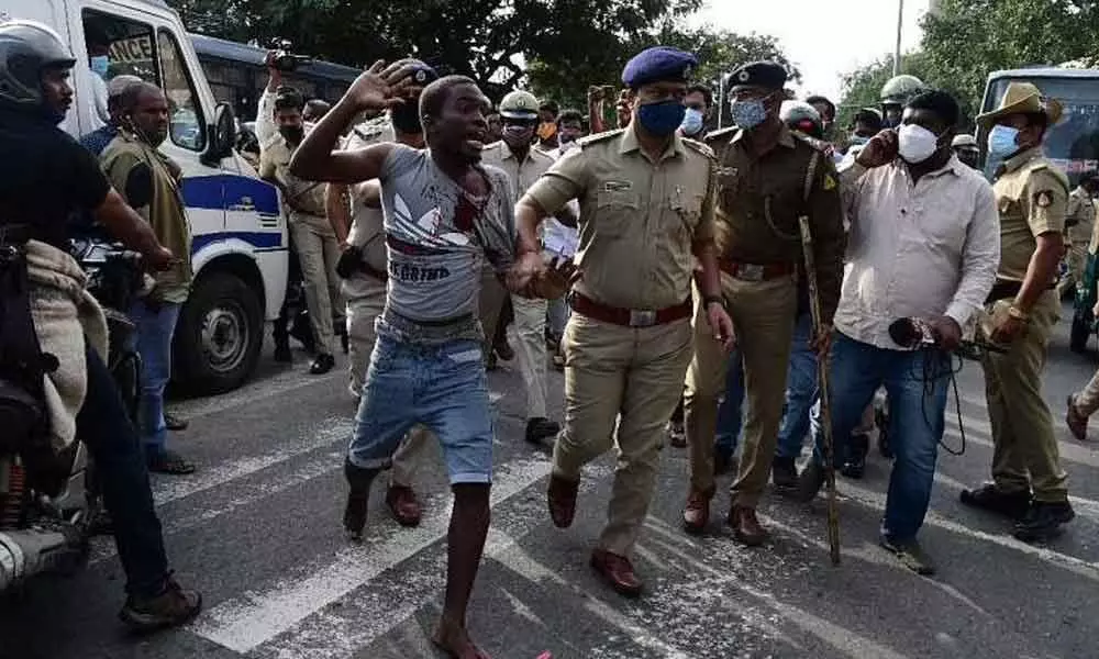 A group of Africans staged a protest outside JC Nagar police station after an alleged custodial death of a Congo national on Monday in Bengaluru (Express Photo | Shriram BN)