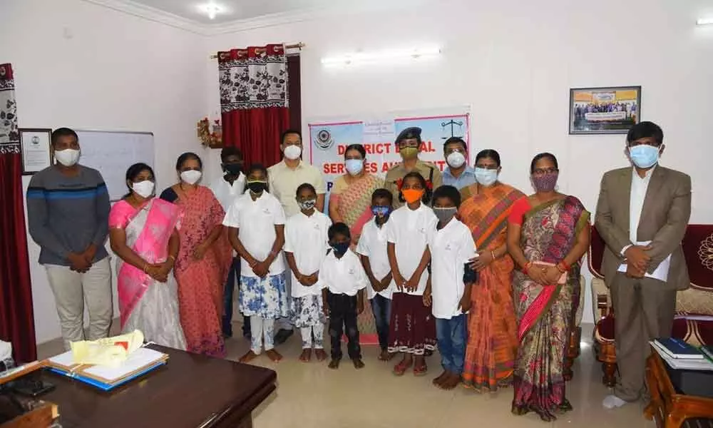 DLSA Chairperson PV Jyothirmai, Collector Pravin Kumar, SP Malika Garg and others with the children joining SOS Children Village Tirupati at district court in Ongole on Monday