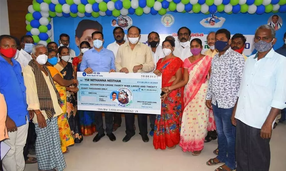 Prakasam district Collector Pravin Kumar, MLAs and officials presenting YSR Nethanna Nestham cheque to beneficiaries in Ongole on Tuesday