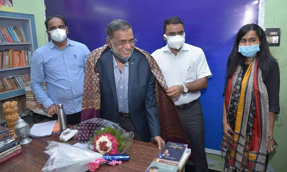 District Collector Vivek Yadav felicitating Dr Katti Padma Rao at his residence in Bapatla on Wednesday