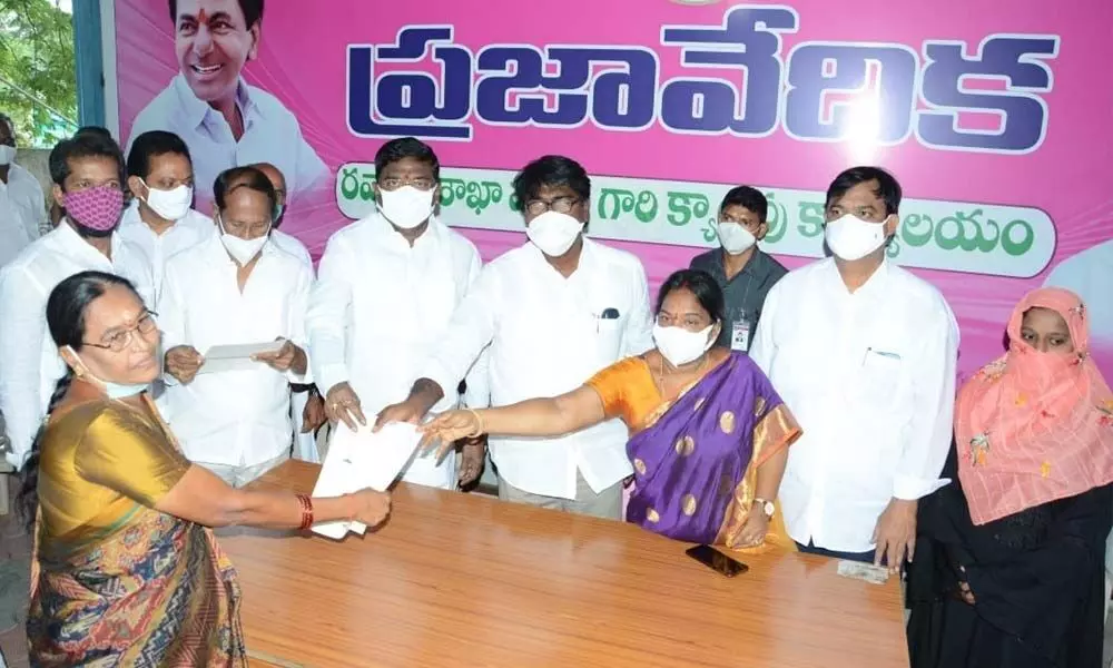 Transport  Minister Puvvada Ajay Kumar giving CMRF cheque to a beneficiary at his camp office in Khammam on Thursday