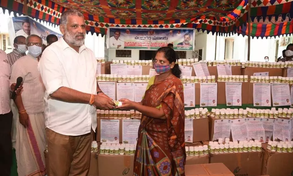 MLA Chevireddy Bhaskar Reddy handing over Anandaiah’s herbal medicine to people of Chandragiri constituency at the Rural MPDO office in Tirupati on Friday