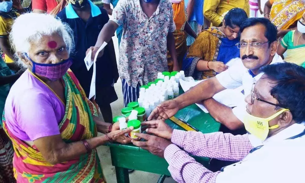 Saikala Foundation chairman Madhusudan and Ayurvedic doctor Vijay Kumar at a free medical camp at Nakkala Colony near Tiruchanur on Friday
