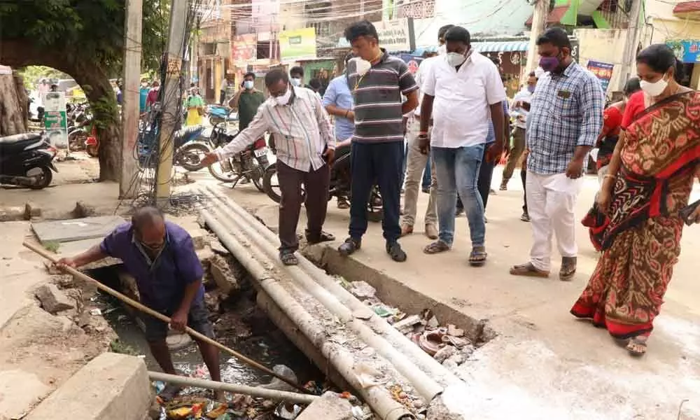 Municipal Commissioner P S Girisha inspecting a clogged drain at Giripuram in Tirupati on Saturday