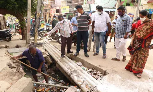 Municipal Commissioner P S Girisha inspecting a clogged drain at Giripuram in Tirupati on Saturday Municipal Commissioner P S Girisha inspecting a clogged drain at Giripuram in Tirupati on Saturday