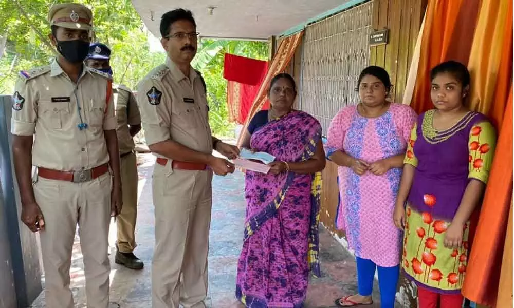 Gudivada DSP N Satyanandam handing over a cheque to the kin of a deceased cop in Kaikaluru on Monday