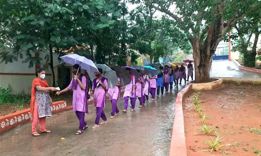 Students entering schools after a long gap as the gates open for them in Visakhapatnam on Monday. 	Photo: Vasu Potnuru