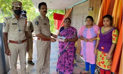 Students getting their hands sanitised before entering the classroom at Thambavani Gunta High School in Tirupati on Monday