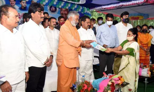Deputy Chief Minsiter K Narayana Swamy and Panchayat Raj Minister P Ramachandra Reddy distributing house site documents to a beneficiary in Srikalahasti on Monday. MLA B Madhusudhan Reddy and Collector M Hari Narayanan are also seen.