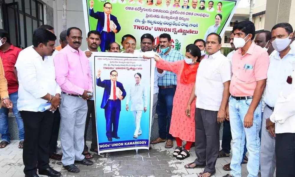 Employees giving milk bath to portrait to Telangana Chief Minister Chandrasekhar Rao in Kamareddy on Tuesday