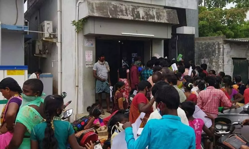 People throng an Aadhaar centre at Podalakur in Nellore district on Tuesday violating Covid norms