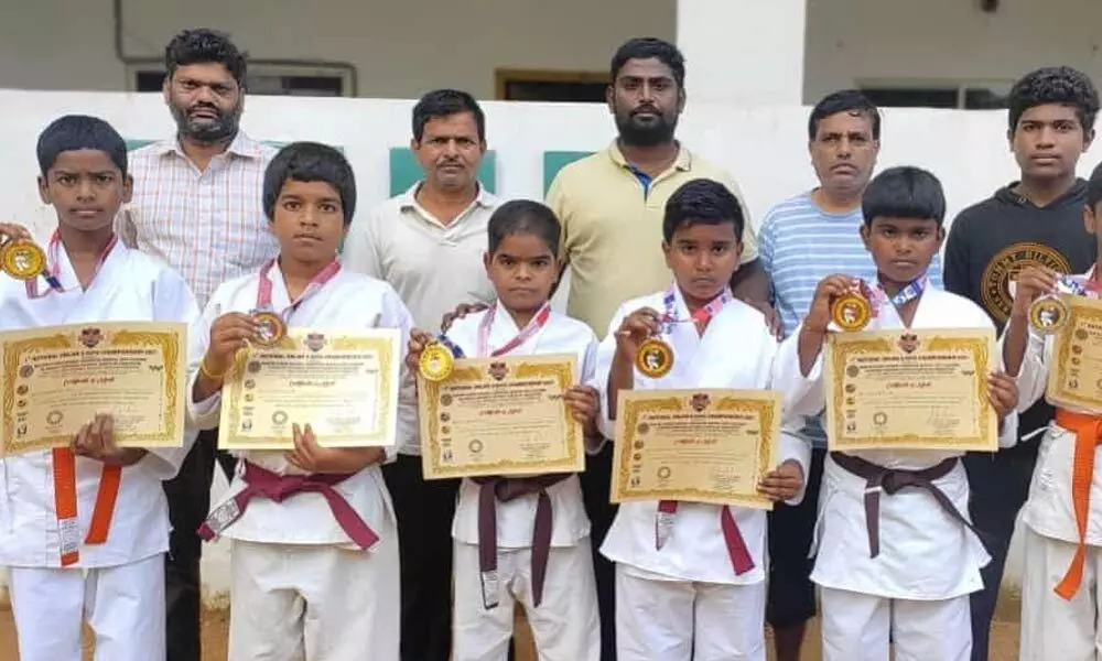 District Karate Association members along with the students, who won medals at national-level E-Kata Karate online championship, in Mahbubnagar on Wednesday