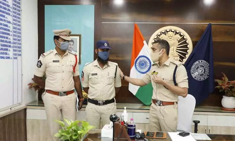 SP Vishal Gunni patting head constable Rafee in Guntur on Wednesday