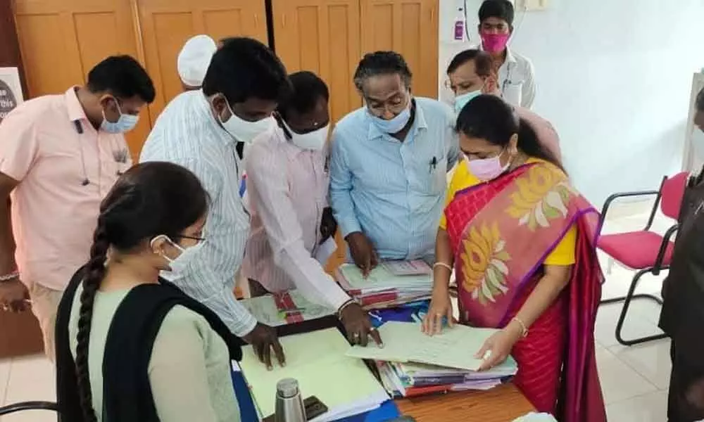 Mayor Gundu Sudharani checking the attendance of employees at the administrative office of GWMC in Warangal on Saturday