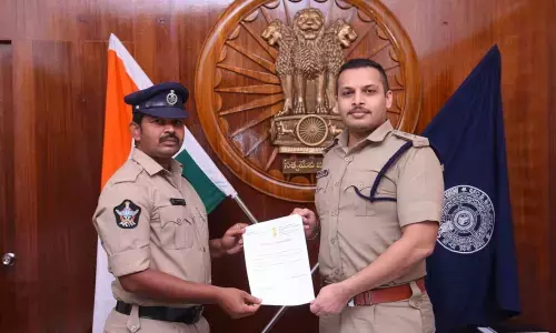 SP Siddharth Kaushal presenting weekly performance reward to constable Ramesh in Machilipatnam on Sunday