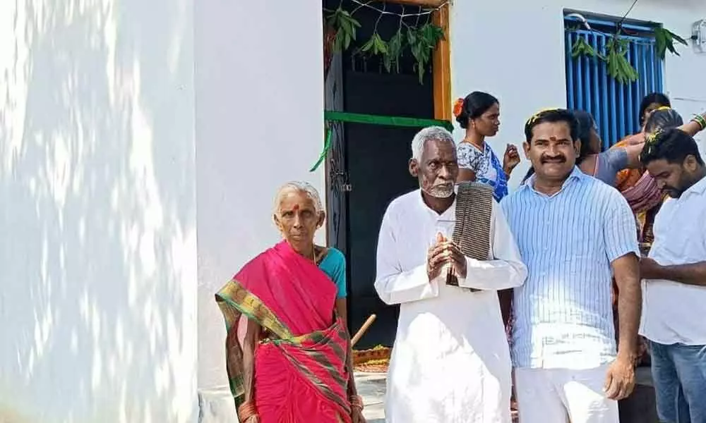 P Sriram (right) along with Ramudu and his wife in front of the newly constructed house