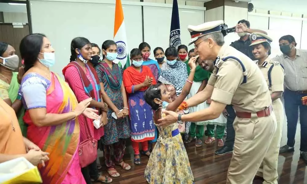 Director General of Police (DGP) D Gautam Sawang celebrating Raksha Bandhan with orphan children at State Police headquarters in Vijayawada on Monday