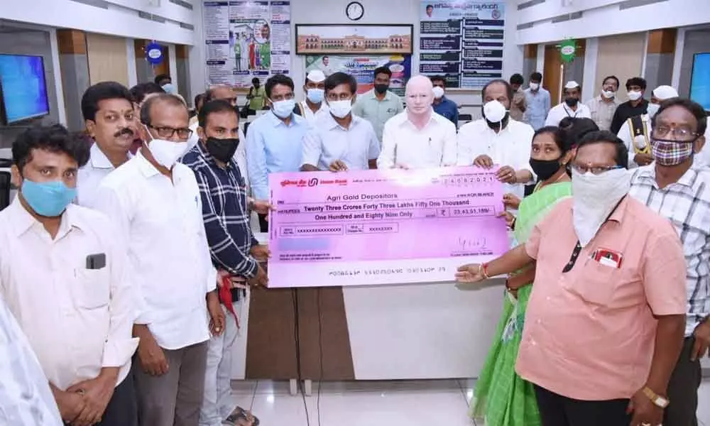 MP Pilli Subhash Chandra Bose and Collector Chevuri Hari Kiran distributing cheque to the AgriGold depositors in Kakinada on Tuesday