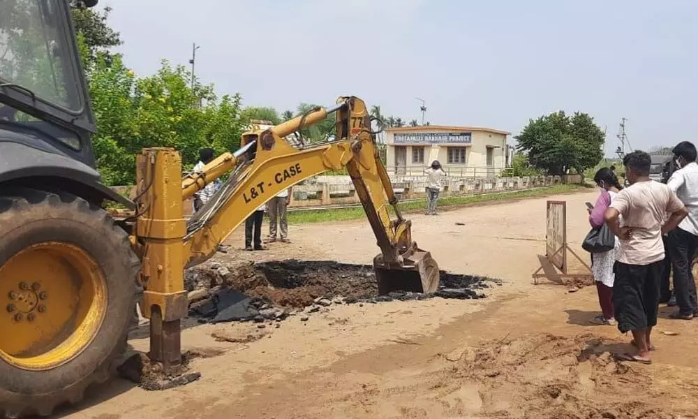 Excavator filling up the sinkholes at bridge of right canal of Thotapalli reservoir