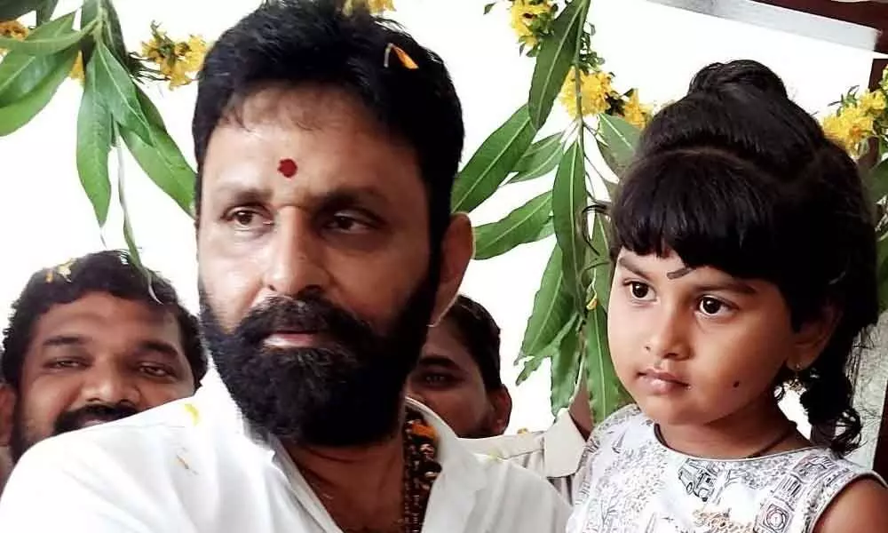 Civil Supplies Minister Kodali Nani with a child at a pre-primary school at Gudivada on Thursday