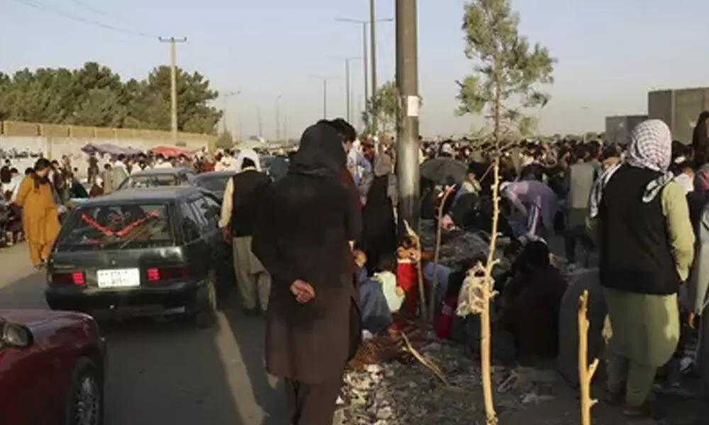 Hundreds of people gather near an evacuation control checkpoint during ongoing evacuations at Hamid Karzai International Airport, in Kabul, Afghanistan