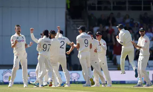 Englands Ollie Robinson (left) and teammates celebrate the dismissal of Indias Cheteshwar Pujara during the fourth day of third Test match at Headingley cricket ground in Leeds, England,  on Saturday