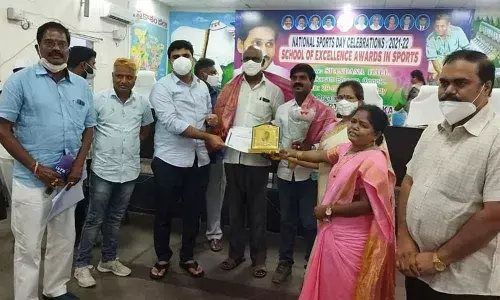 Joint Collector TS Chetan and other officials felicitating headmaster K Sivaji and PET Hazarathaiah of ZPHS Pakala in Ongole on Monday