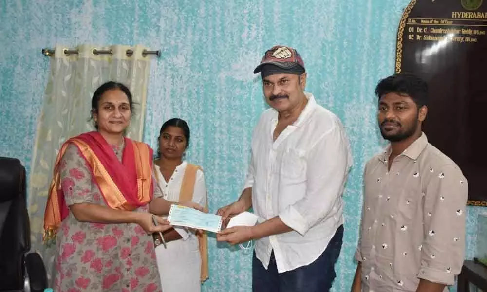 Tollywood actor Kondidela Nagababu presenting a cheque to VVL Subhadra Devi, Curator of Nehur Zoological Park, in Hyderabad on Tuesday