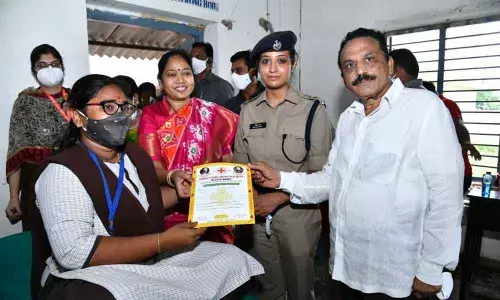 Home Minister Mekathoti Sucharia, Madyavimochana Prachara Committee chairman Vallamreddy Lakshmana Reddy, SP Malika Garg presenting a certificate to a blood donor at Karumanchi on Wednesday