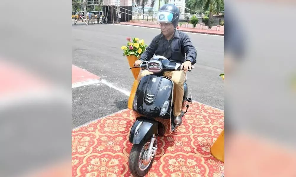 DRM, Waltair Division Anup Kumar Satpathy riding an e-bike launched at Visakhapatnam railway station on Saturday