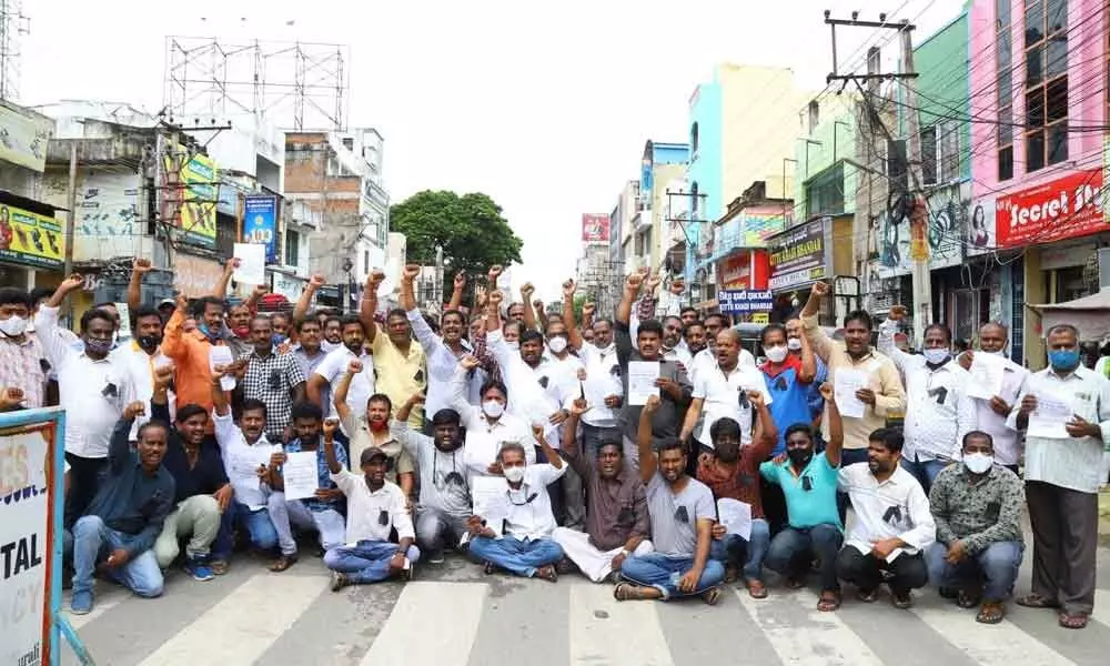 Photo studio and color labs owners staging a protest condemning manhandling of a photographer in Anantapur, at Gandhi Road in Tirupati on Monday