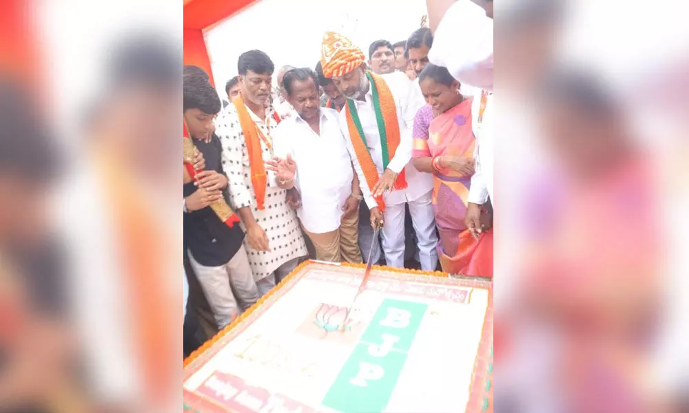 BJP State chief Bandi Sanjay cutting a cake on the completion of 100 km padayatra at Mominpet on Monday